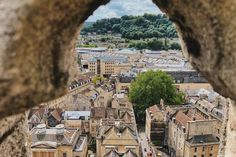 an aerial view of the city through a hole in a stone wall