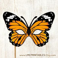 an orange and black butterfly mask on a white wooden background with text that reads free printables