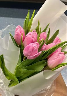 a bouquet of pink tulips wrapped in plastic