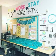 a classroom with desks and chairs in front of a sign that says play work stay nice