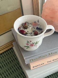 a cup of tea sitting on top of a stack of books next to a rock