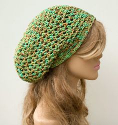 a mannequin head wearing a green and brown crochet knitted hat