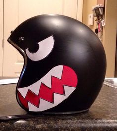 a black helmet with red and white teeth on it