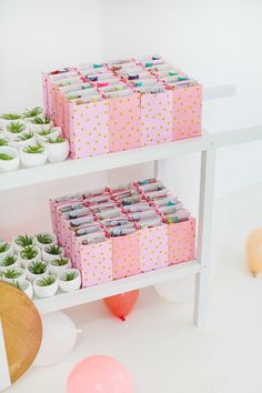 two shelves filled with boxes and balloons on top of white floored area next to wall