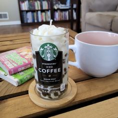 a cup of coffee sitting on top of a wooden table next to a book shelf