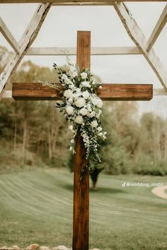 a cross decorated with flowers and greenery