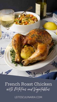 a white plate topped with a roasted chicken next to a bowl of potatoes and vegetables