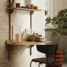 a table with some books on it next to a chair and potted plant in the corner