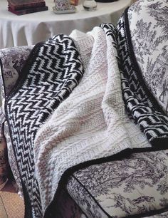 a white and black blanket sitting on top of a couch