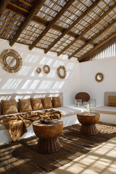 a living room filled with lots of furniture under a sunlit roof over looking the ocean