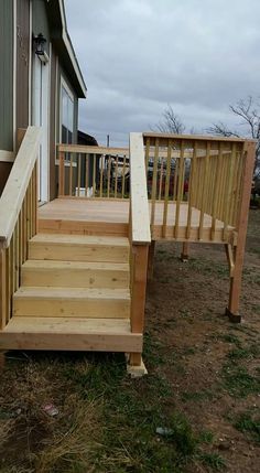 a wooden stair case next to a house