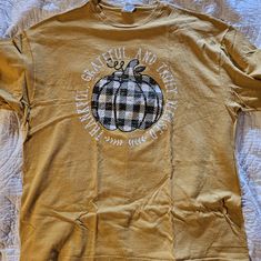 a yellow shirt with a black and white pumpkin on it