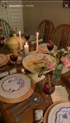 a table set with plates, silverware and candles