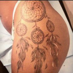 a woman's thigh with a dream catcher tattoo on it