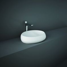 a white bowl sink sitting on top of a counter next to a faucet