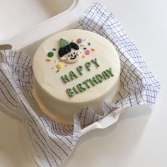 a birthday cake sitting on top of a blue and white checkered cloth covered tray