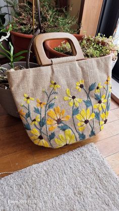 a handbag is sitting on the floor next to some potted plants and a rug