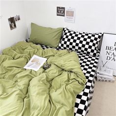 an unmade bed with green sheets and black and white checkerboard comforter