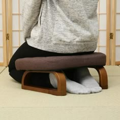 a woman sitting on top of a wooden chair