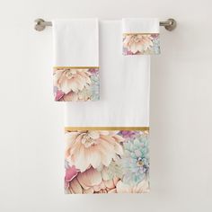 two towels hanging on a towel rack with flowers painted on them and gold trimmings