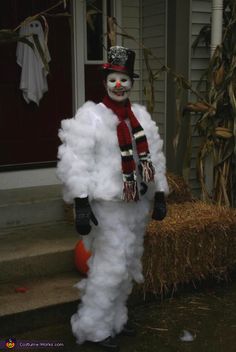 a man dressed up as a snowman in front of a house