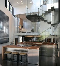 an open living room with stairs leading up to the second floor and dining table in front of it