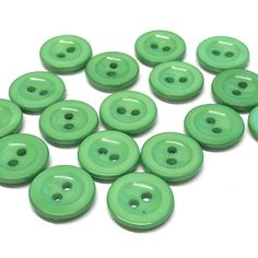 green buttons are arranged on a white surface