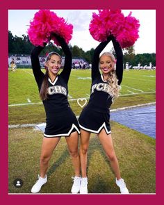 two cheerleaders in black and pink outfits with pom poms on their heads