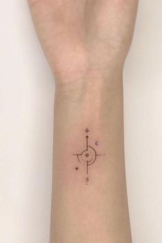 a hand with a wrist tattoo that has a compass on it and stars in the middle