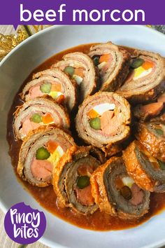 a white bowl filled with meat and sauce on top of a wooden table next to a purple sign that says beef morcon