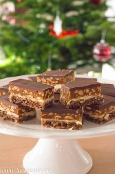 there are many pieces of chocolate and nuts on the cake platter that is ready to be eaten