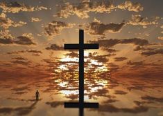 a cross with the sun shining behind it