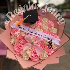 a bouquet of pink and white roses with a graduation cap on top that says congratulations