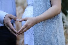 two people making a heart shape with their hands