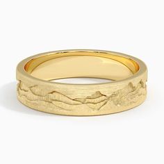 a yellow gold wedding ring with mountains in the middle and waves on it's sides