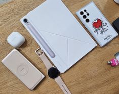 an assortment of electronics and accessories laid out on a wooden table next to each other