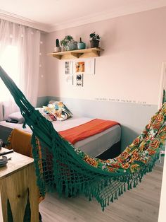 a bedroom with a bed and a hammock hanging from the ceiling in it