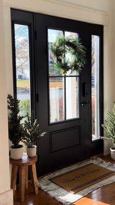 the front door is decorated with wreaths and potted plants