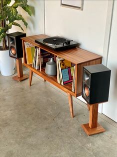 a record player is sitting on top of a table with speakers and bookshelves