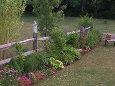 a wooden fence surrounded by flowers and plants