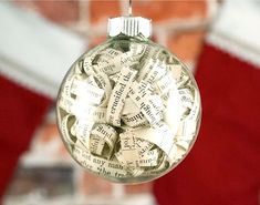 a glass ornament with words on it hanging from a string in front of a brick wall