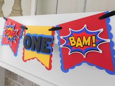 a birthday banner with the words one bam on it hanging from a fireplace mantel