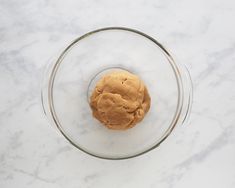 a cookie in a glass bowl on a marble surface