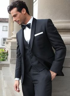 a man in a tuxedo is standing outside