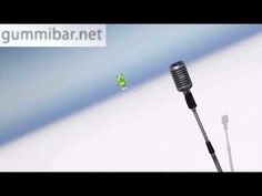 an old microphone with the word gummba on it and a small green object in the background