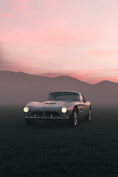 an old car parked in the middle of a field