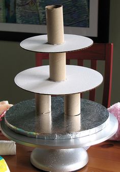 a three tiered cake stand sitting on top of a wooden table