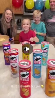 a group of people sitting at a table with cans of drinks