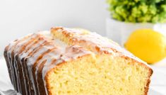 a close up of a cake on a plate with lemons and a vase in the background