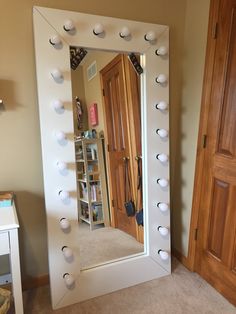 a mirror that is in the middle of a room with white balls on it and some bookshelves behind it